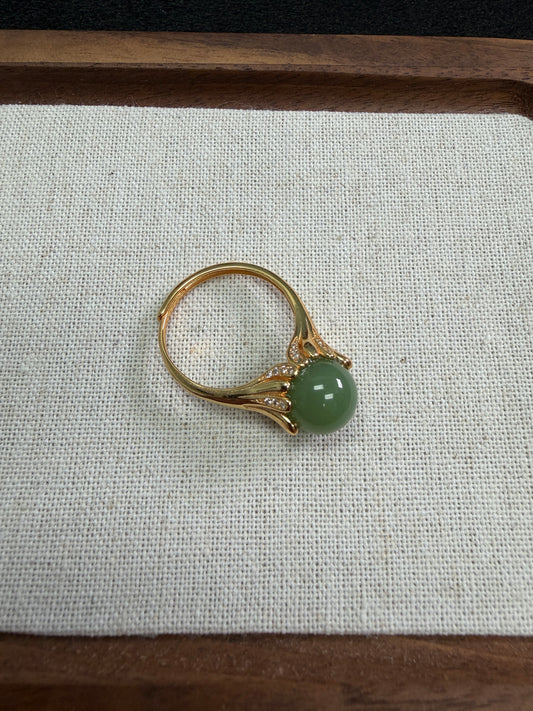 Silver ring with a green gemstone on a textured fabric background