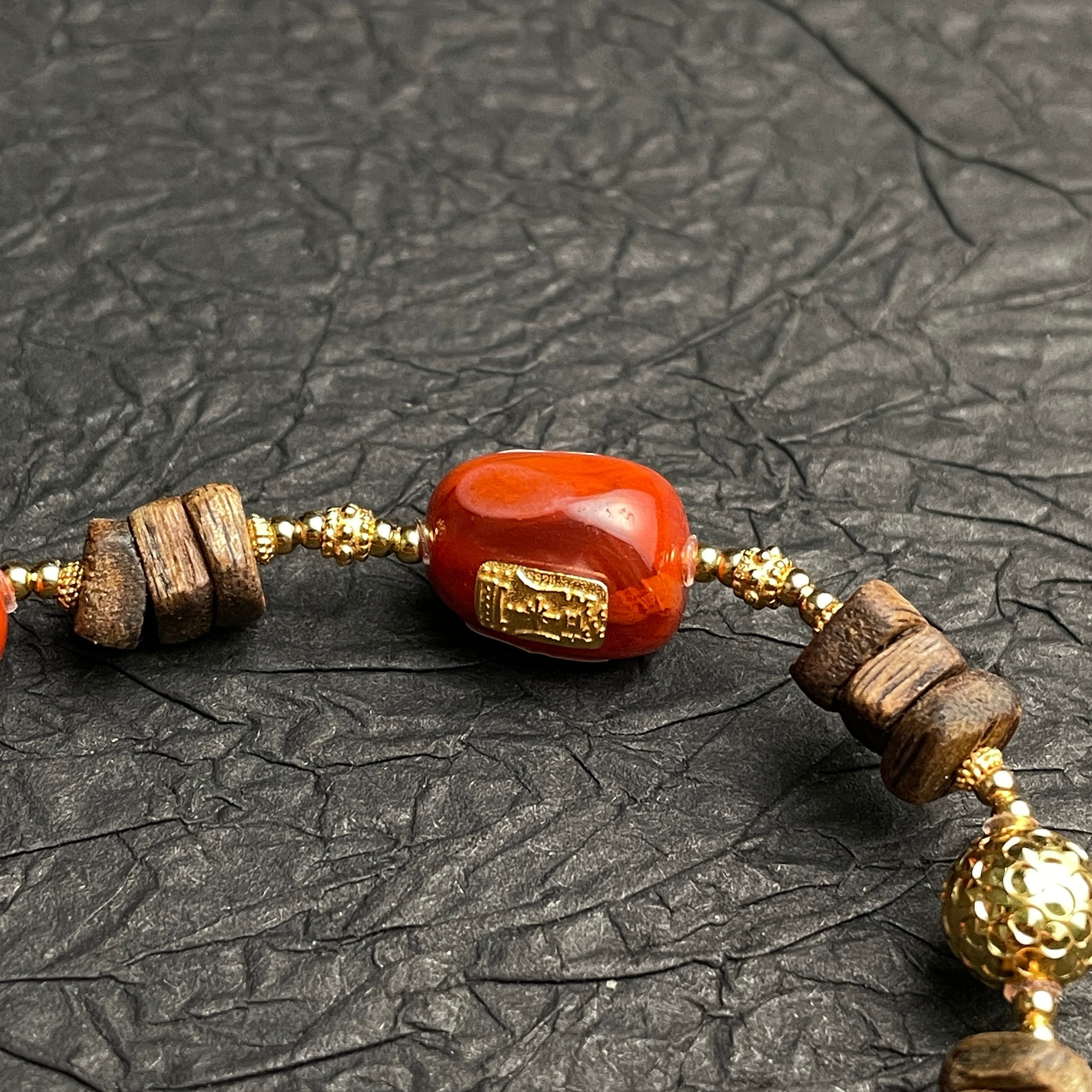 Sylvia Jewelry red Nanhong Agate and natural Agarwood beaded bracelet with gold-plated accents.