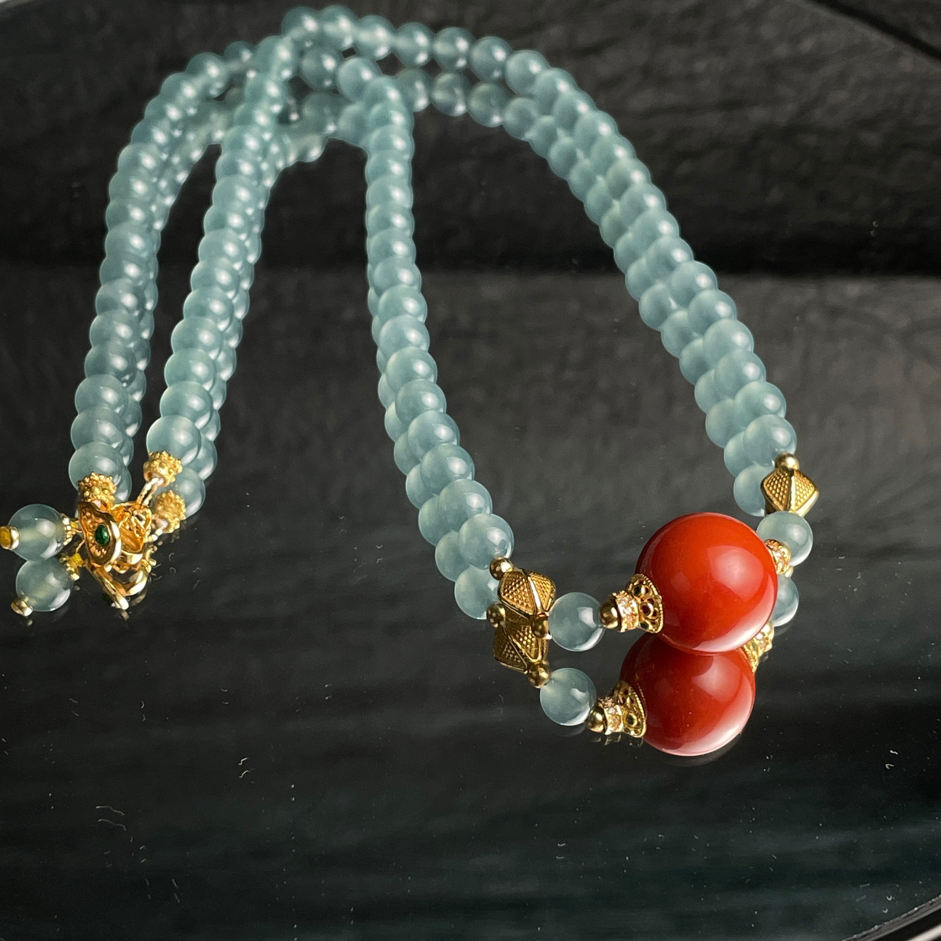 Sylvia Jewelry 浅蓝色珠子项链,带有两个红色珊瑚珠和金色配件,适合日常佩戴。