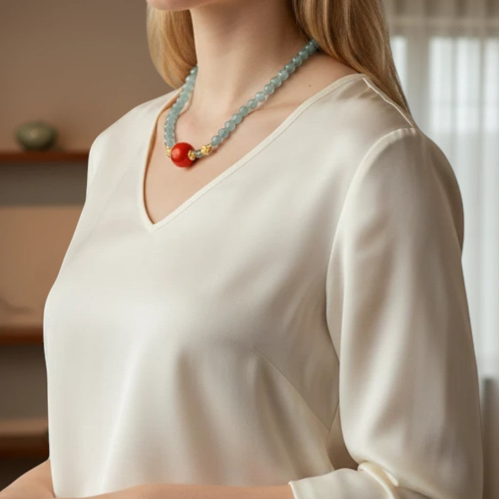 Sylvia Jewelry 浅蓝色串珠项链,配有红色圆形吊坠和金色细节。