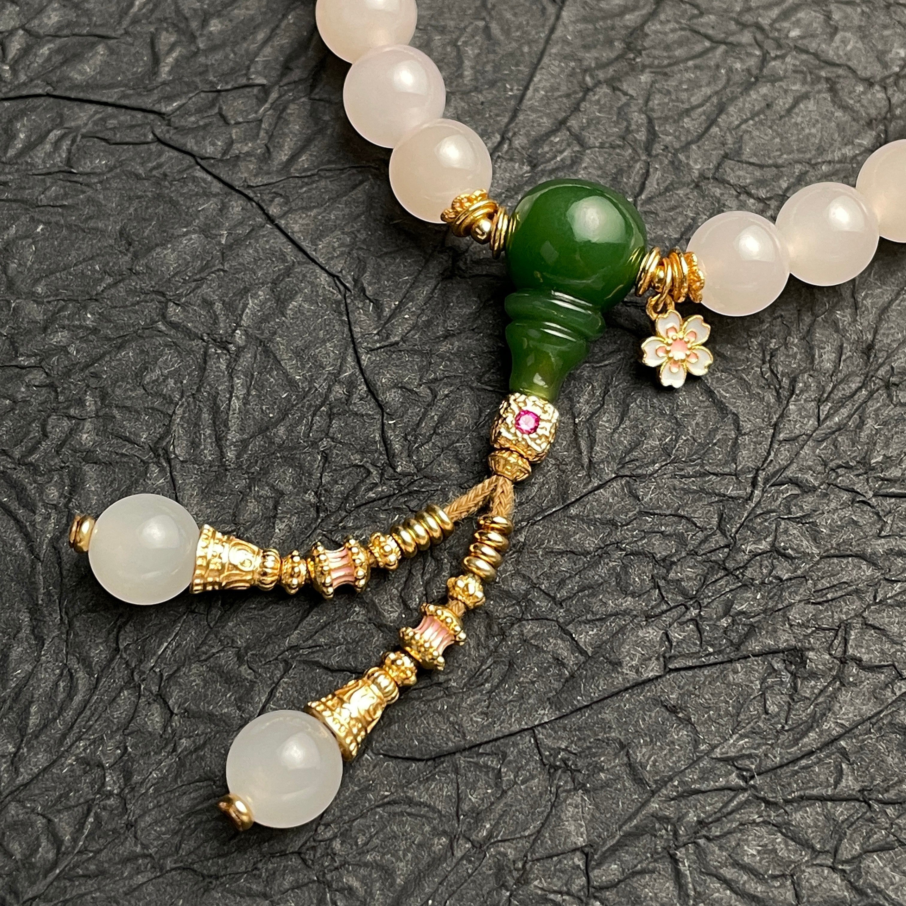 Sylvia Jewelry 粉色水晶和绿色玉石串珠手链,带有金色流苏和花朵吊坠。