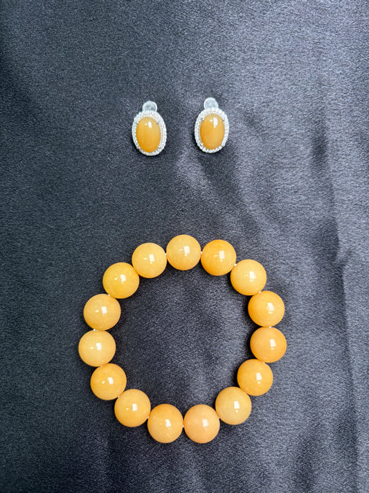 Yellow beaded bracelet and earrings on a gray fabric background