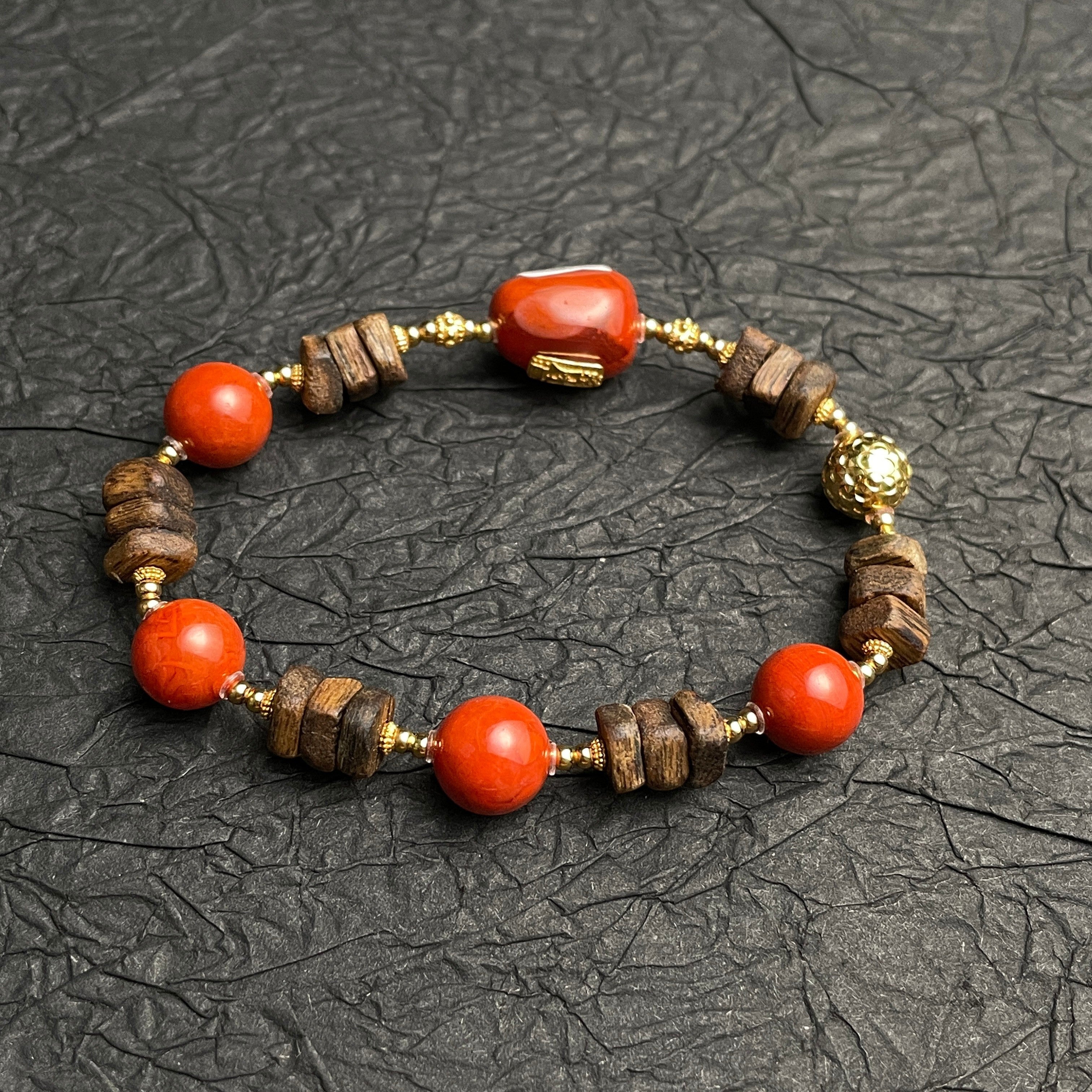Sylvia Jewelry Nanhong Agate and Agarwood beaded bracelet with gold accents. Features red agate beads and natural wood beads.