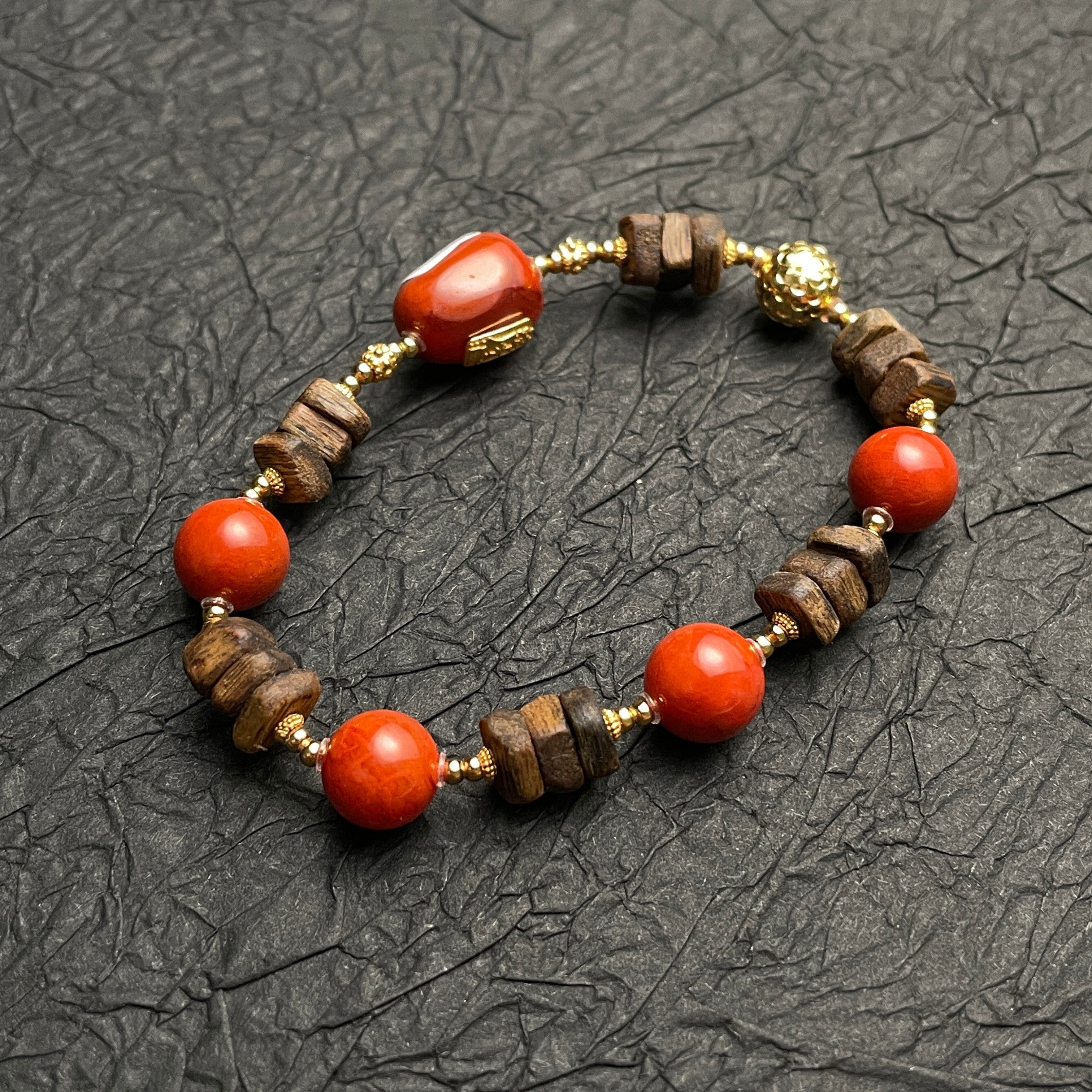 Sylvia Jewelry Nanhong Agate and Agarwood beaded bracelet with gold-plated accents. Features vibrant red agate beads and natural wood beads.