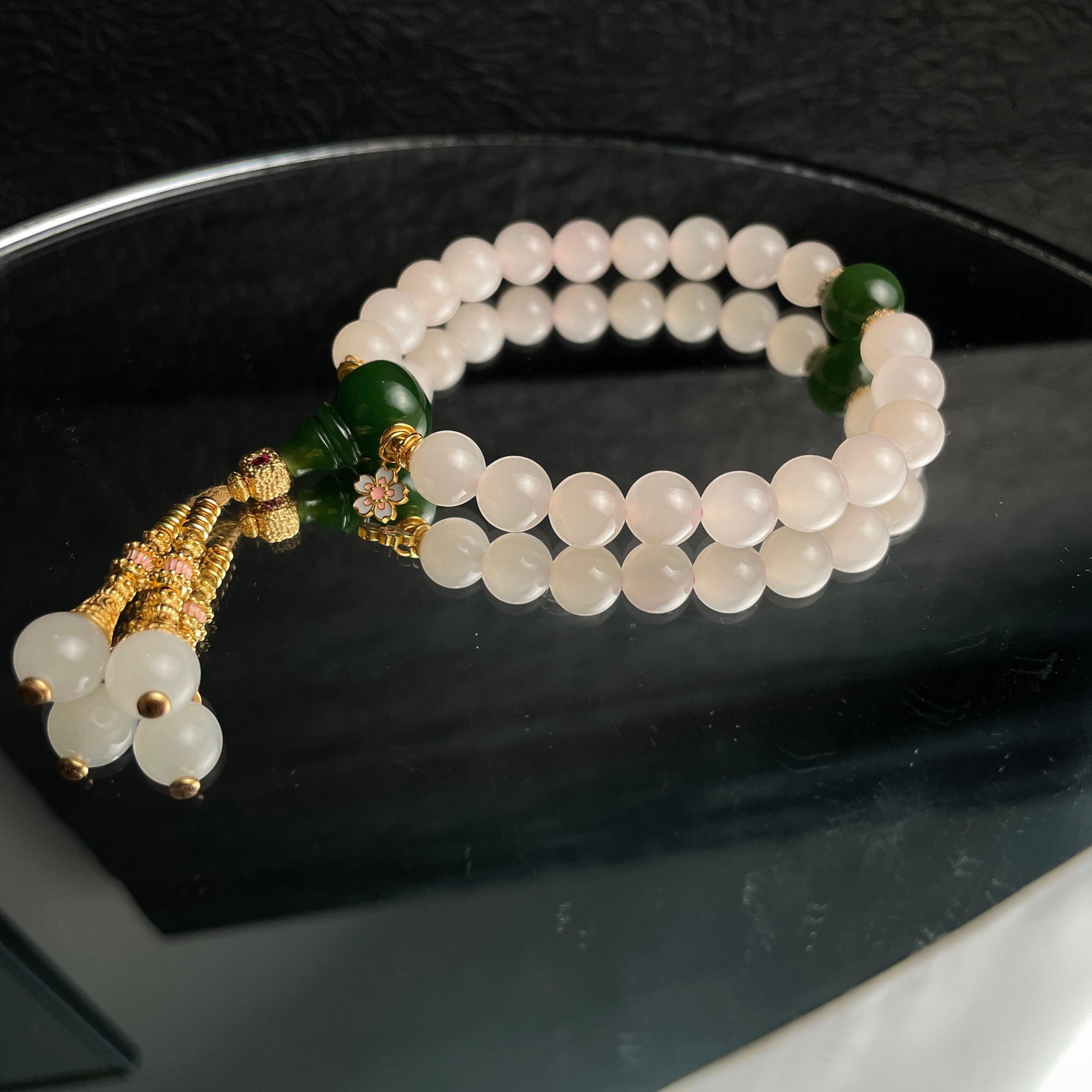 Sylvia Jewelry 粉色水晶珠子手链，配有绿色玉石和金色流苏吊坠，适合日常佩戴。