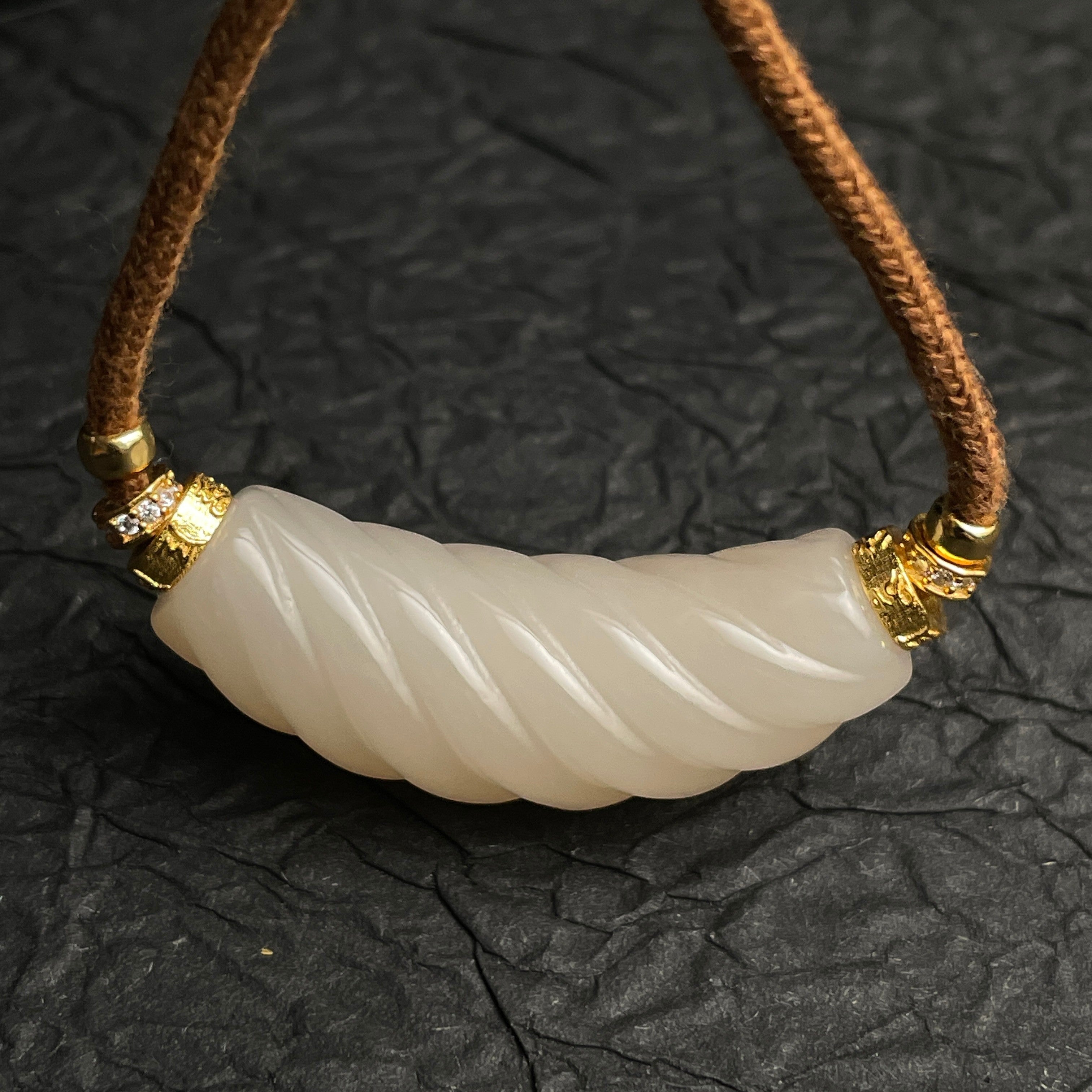 Sylvia Jewelry 扭纹粉色和田玉吊坠，金色镶嵌，搭配棕色绳链，适合日常优雅佩戴。
