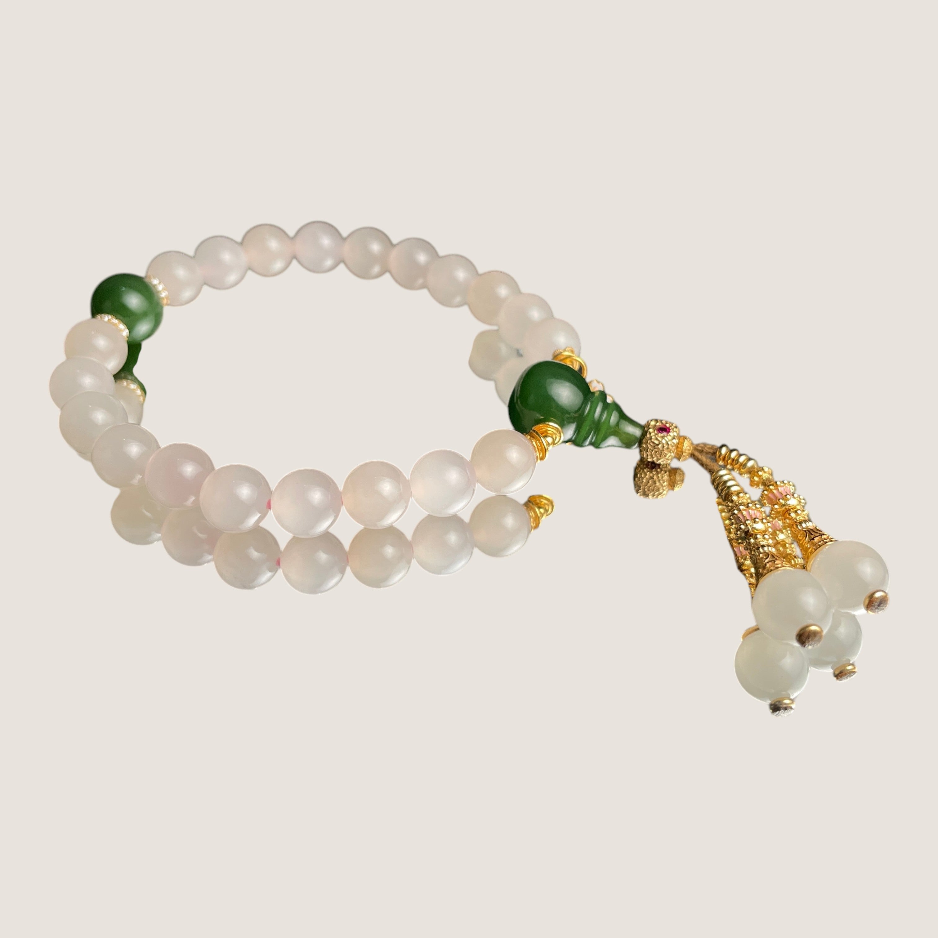 Sylvia Jewelry 浅粉色玉石佛珠手链，点缀绿色玛瑙和金色流苏，适合日常佩戴。