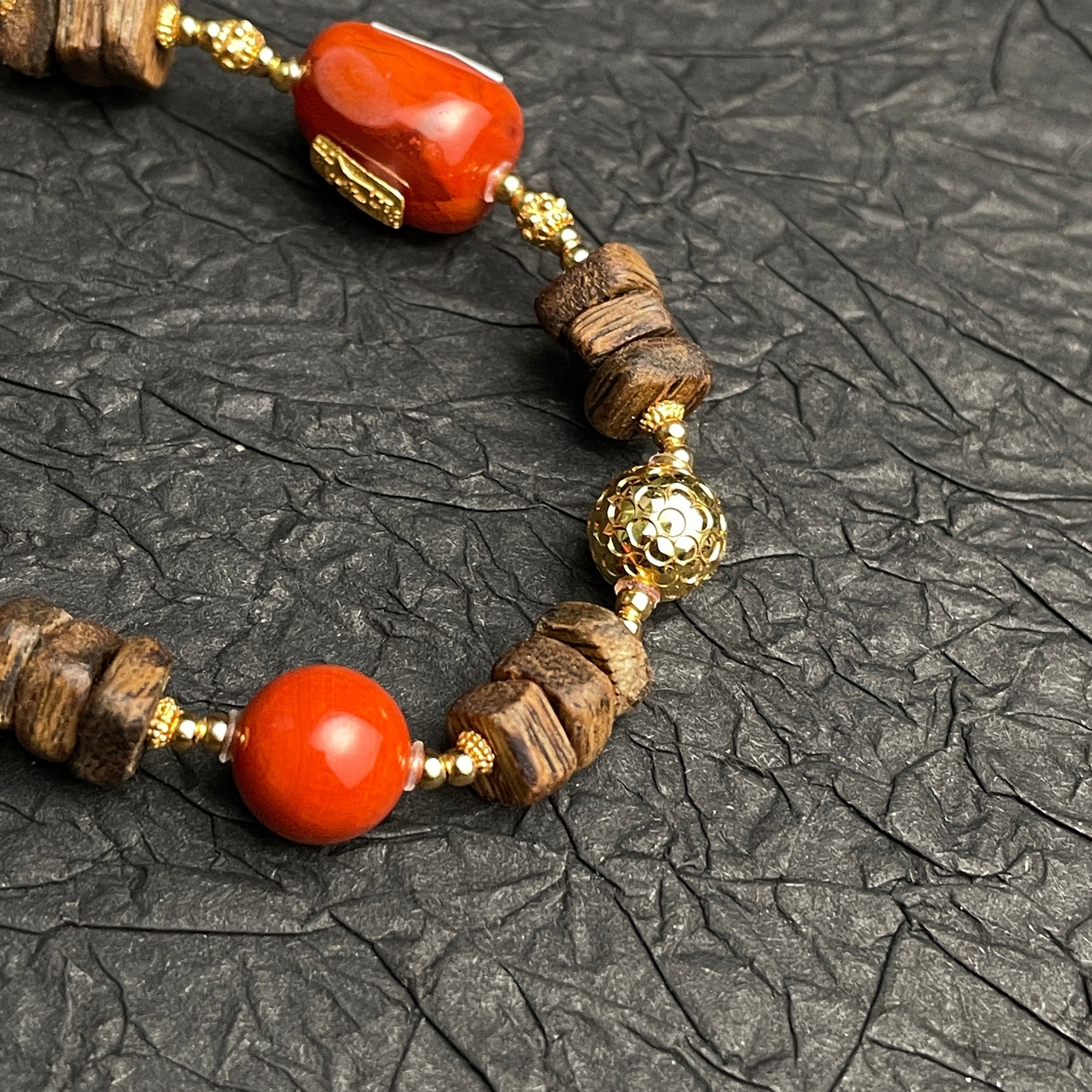 Sylvia Jewelry Nanhong Agate & Agarwood beaded bracelet with gold accents. Features red agate beads and natural agarwood.